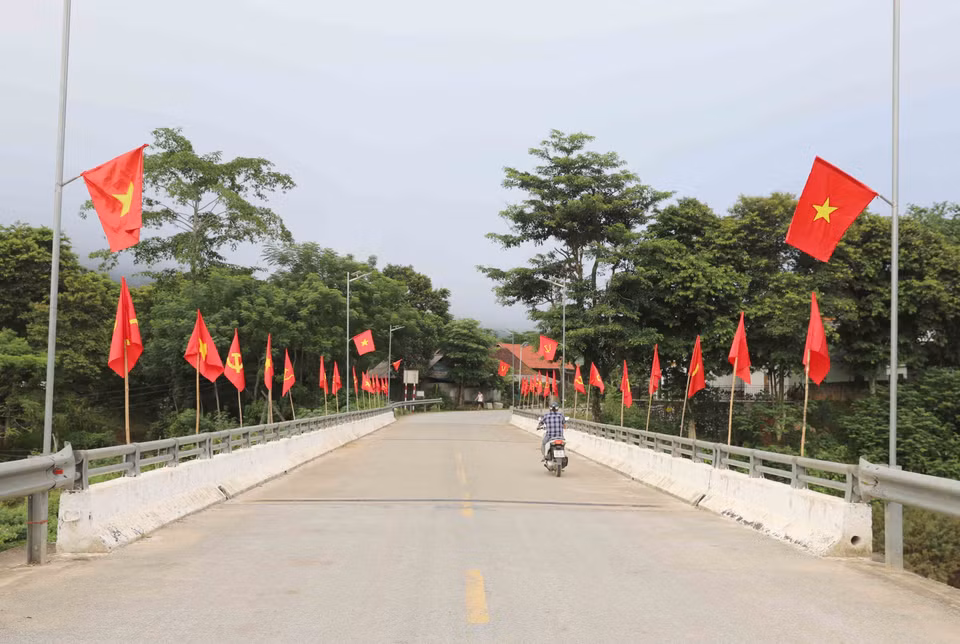 Cờ Tổ quốc được cắm trên cầu Bản Pột (quốc lộ 48C), là cửa ngõ vào trung tâm xã miền núi, vùng cao Nga My (huyện Tương Dương, Nghệ An). (Ảnh: Xuân Tiến/TTXVN)