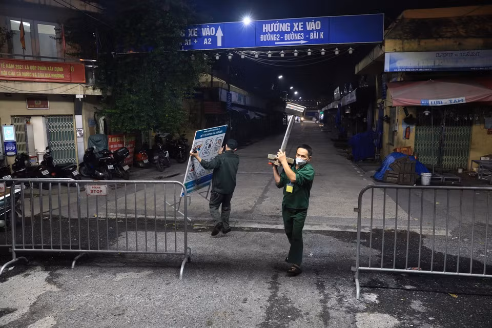 Đúng 0h ngày 21/10/2021, lực lượng chức năng gỡ rào phong tỏa, chợ Long Biên chính thức mở cửa hoạt động trở lại. (Ảnh: Thành Đạt/TTXVN)