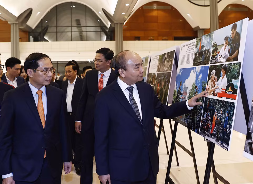 Chủ tịch nước Nguyễn Xuân Phúc xem trưng bày ảnh tại Chương trình Xuân Quê hương năm 2023. (Ảnh: Thống Nhất/TTXVN)
