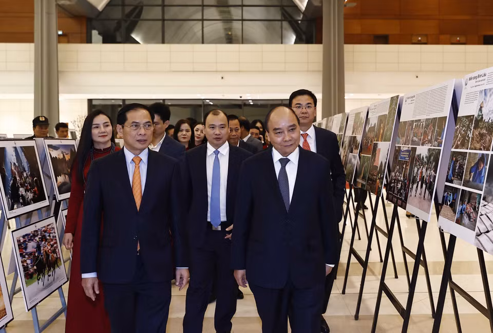 Chủ tịch nước Nguyễn Xuân Phúc xem trưng bày ảnh tại Chương trình Xuân Quê hương năm 2023. (Ảnh: Thống Nhất/TTXVN)