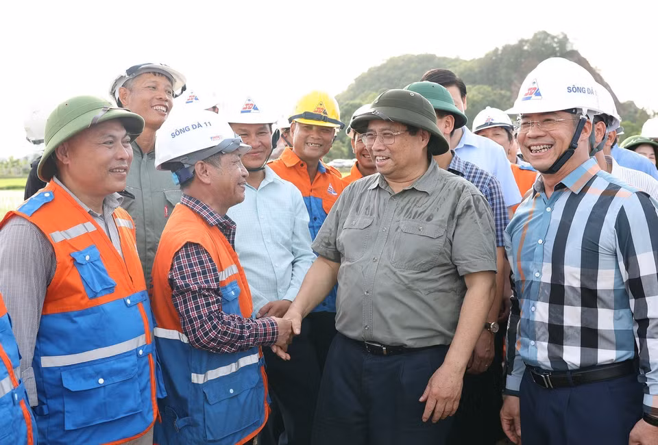 Thủ tướng Phạm Minh Chính thăm, động viên công nhân thi công kéo dây khoảng néo 109-117 tại xã Cầu Lộc, huyện Hậu Lộc, tỉnh Thanh Hóa. (Ảnh: Dương Giang/TTXVN)