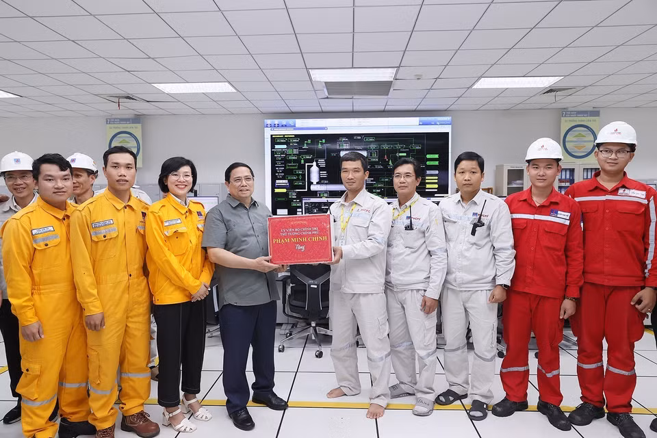 Thủ tướng Phạm Minh Chính tặng quà cho kỹ sư, công nhân Cụm Công nghiệp Khí-Điện-Đạm Cà Mau. (Ảnh: Dương Giang/TTXVN)