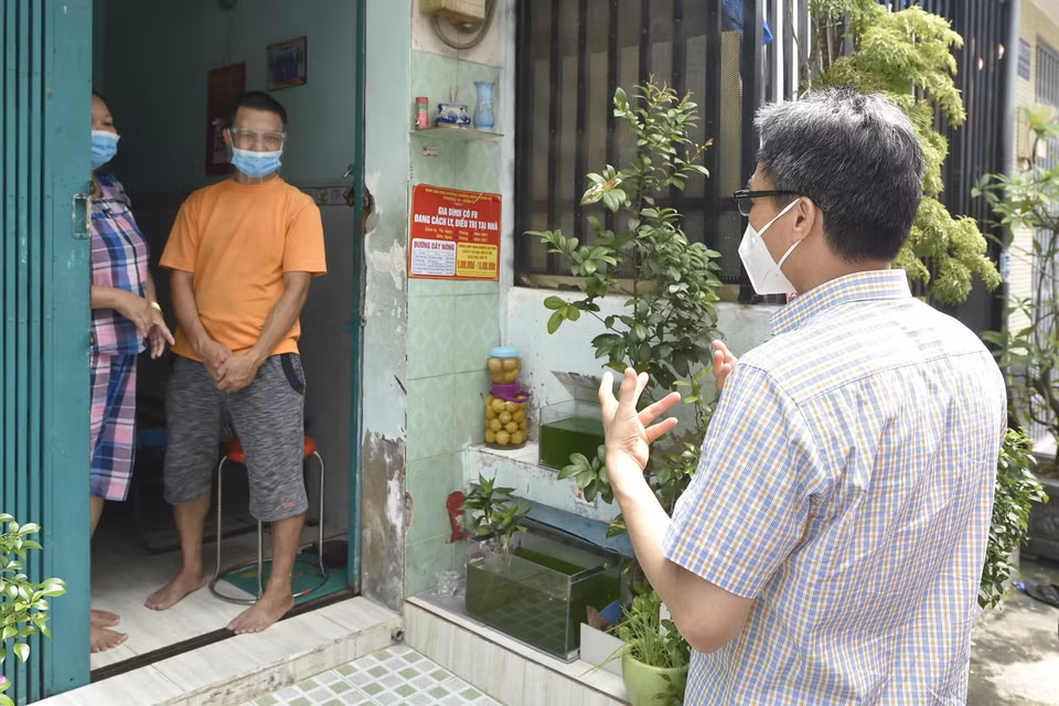 Phó Thủ tướng Vũ Đức Đam thăm một gia đình đang có F0 cách ly tại nhà trên đường Lý Chiêu Hoàng, Phường 10, Quận 6. (Ảnh: TTXVN phát)