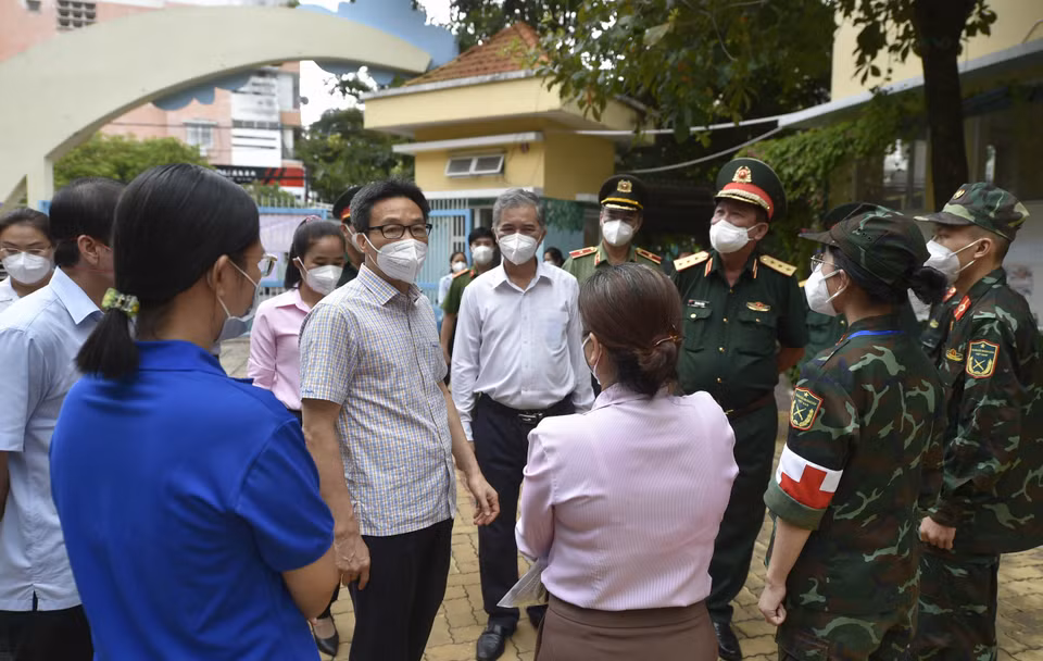 Phó Thủ tướng Vũ Đức Đam động viên lực lượng chức năng tham gia chống dịch trên địa bàn Quận 6.(Ảnh: TTXVN phát)