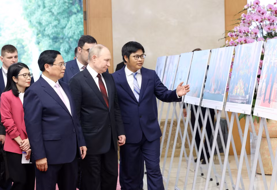 Thủ tướng Phạm Minh Chính và Tổng thống Liên bang Nga Vladimir Putin xem trưng bày ảnh về quan hệ Việt Nam-Nga. (Ảnh: Dương Giang/ TTXVN)
