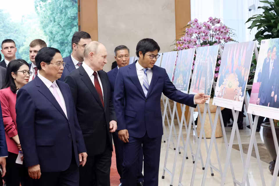 Thủ tướng Phạm Minh Chính và Tổng thống Liên bang Nga Vladimir Putin xem trưng bày ảnh về quan hệ Việt Nam-Nga. (Ảnh: Dương Giang/ TTXVN)