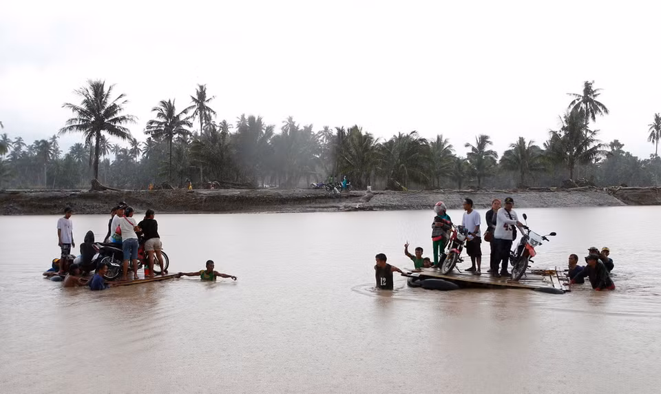 Người dân di chuyển bằng bè để qua sông sau bão Tembin tại tỉnh Lanao del Norte, Philippines ngày 23/12. (Nguồn: THX/TTXVN)