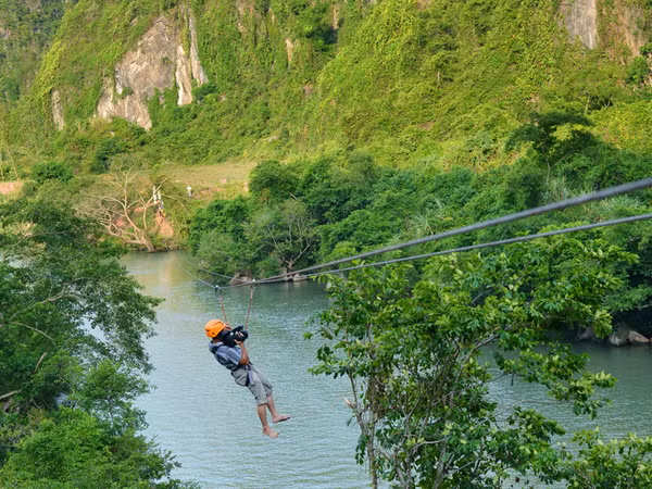 Du khách tham gia dịch vụ du lịch đu dây trên không tại tuyến du lịch sông Chày-hang Tối. (Ảnh: Đức Thọ-Mạnh Thành/TTXVN)