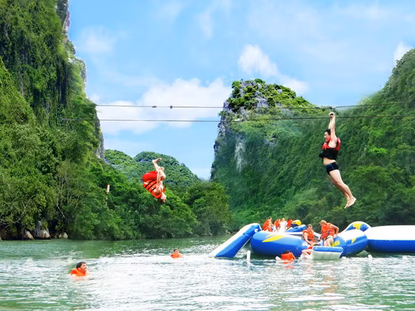 Du khách tham gia dịch vụ du lịch đu dây trên không tại tuyến du lịch sông Chày-hang Tối. (Ảnh: Đức Thọ-Mạnh Thành/TTXVN)