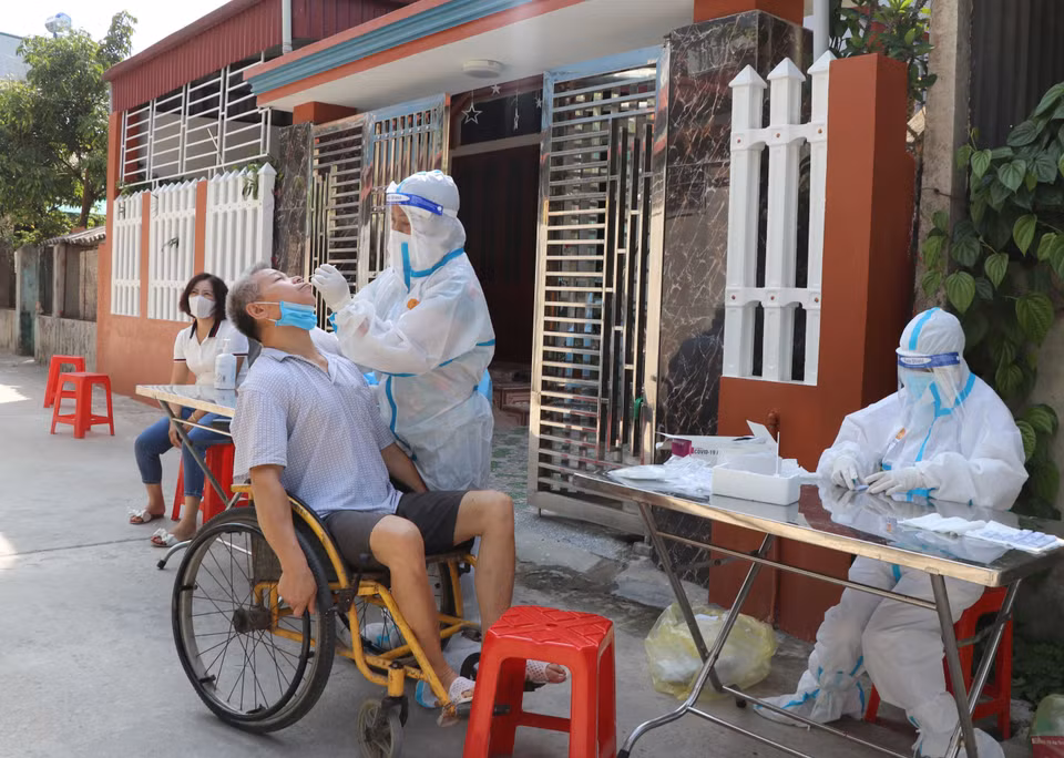 Tiến hành lấy mẫu xét nghiệm cho người vận động hạn chế sinh sống trong vùng thiết lập cách ly. (Ảnh: Xuân Tiến/TTXVN)