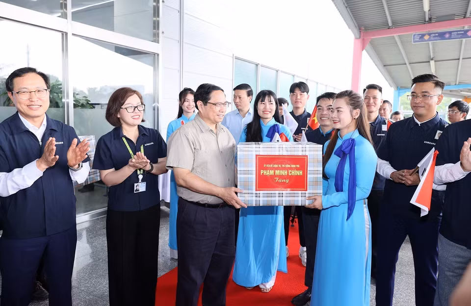 Thủ tướng Phạm Minh Chính tặng quà cho đại diện lãnh đạo, nhân viên Công ty TNHH Samsung Việt Nam. (Ảnh: Dương Giang/TTXVN)