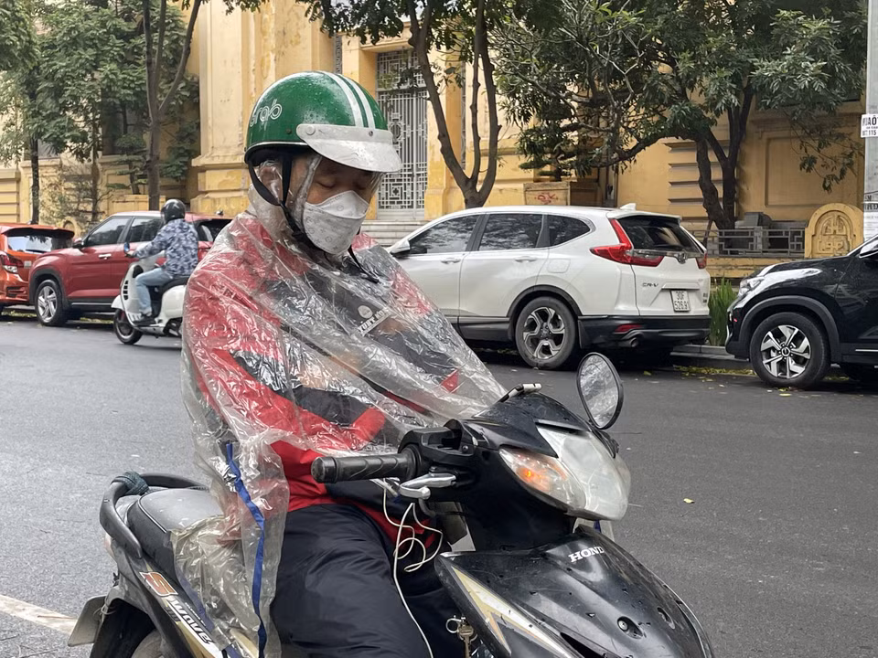 Một tài xế công nghệ đang tranh thủ nghỉ ngơi bên lề phố. (Ảnh: PV/Vietnam+)
