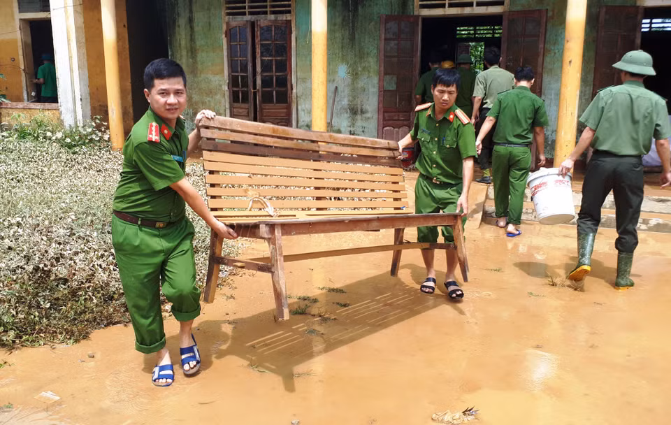 Các chiến sỹ công an huyện Hương Khê (Hà Tĩnh) chung tay dọn vệ sinh môi trường sau lũ tại xã Hương Đô. (Ảnh: Phan Quân/TTXVN)