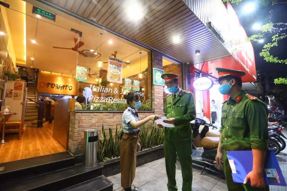 Công an phường Nguyễn Du (Hà Nội) tuyên truyền, nhắc nhở các cửa hàng đóng cửa theo quy định phòng chống dịch COVID-19 (26/3/2020). (Ảnh: Minh Quyết/TTXVN)