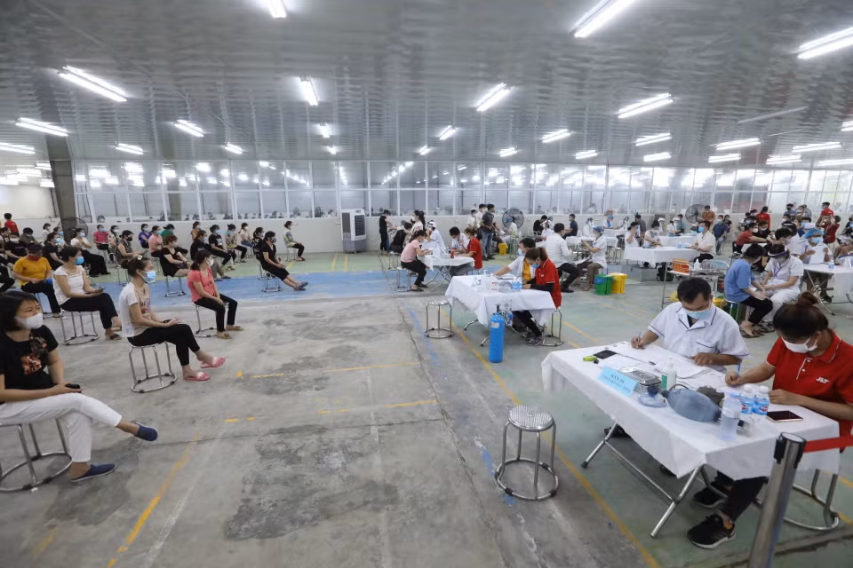 Ngày 28/7/2021, huyện Mê Linh tổ chức tiêm vaccine cho công nhân lao động tại các công ty thuộc Khu công nghiệp Quang Minh. (Ảnh: Minh Quyết/TTXVN)