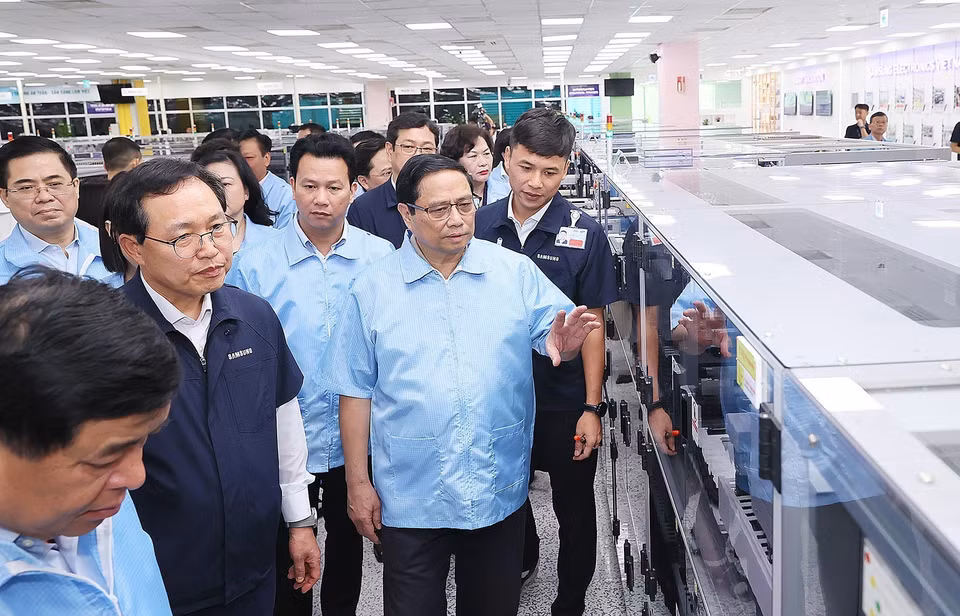 Thủ tướng Phạm Minh Chính thăm dây chuyền sản xuất thiết bị điện tử của Công ty TNHH Samsung Việt Nam. (Ảnh: Dương Giang/TTXVN)