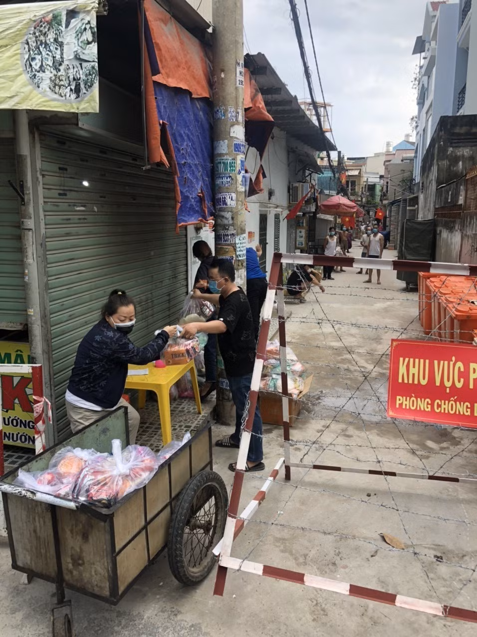 Các tổ chức, đoàn thể cung cấp nhu yếu phẩm cho người dân trong khu vực cách ly tại hẻm 637/37 Quang Trung, quận Gò Vấp, Tp.Hồ Chí Minh. (Ảnh: Anh Tuấn/TTXVN)