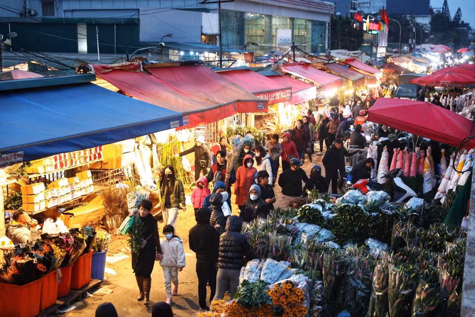 Từ sáng sớm đến đêm khuya, chợ hoa Quảng An đều nhộn nhịp kẻ bán, người mua. (Ảnh: Tuấn Anh/TTXVN)
