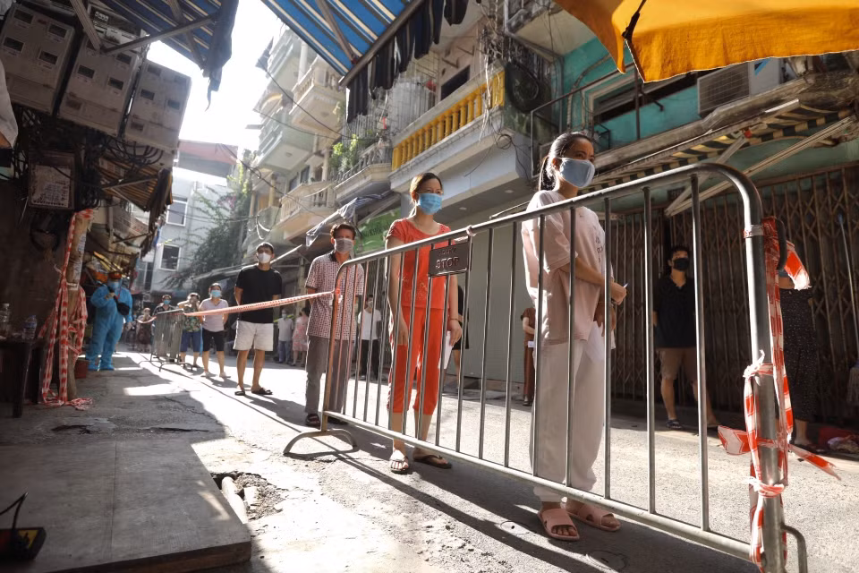 Cư dân ngõ 495 Bạch Mai, quận Hai Bà Trưng, xếp hàng chờ lấy mẫu xét nghiệm COVID-19. (Ảnh: Minh Quyết/TTXVN)