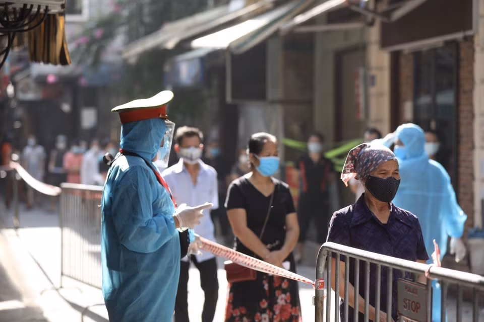 Cư dân ngõ 495 Bạch Mai, quận Hai Bà Trưng đến lấy mẫu xét nghiệm COVID-19. (Ảnh: Minh Quyết/TTXVN)