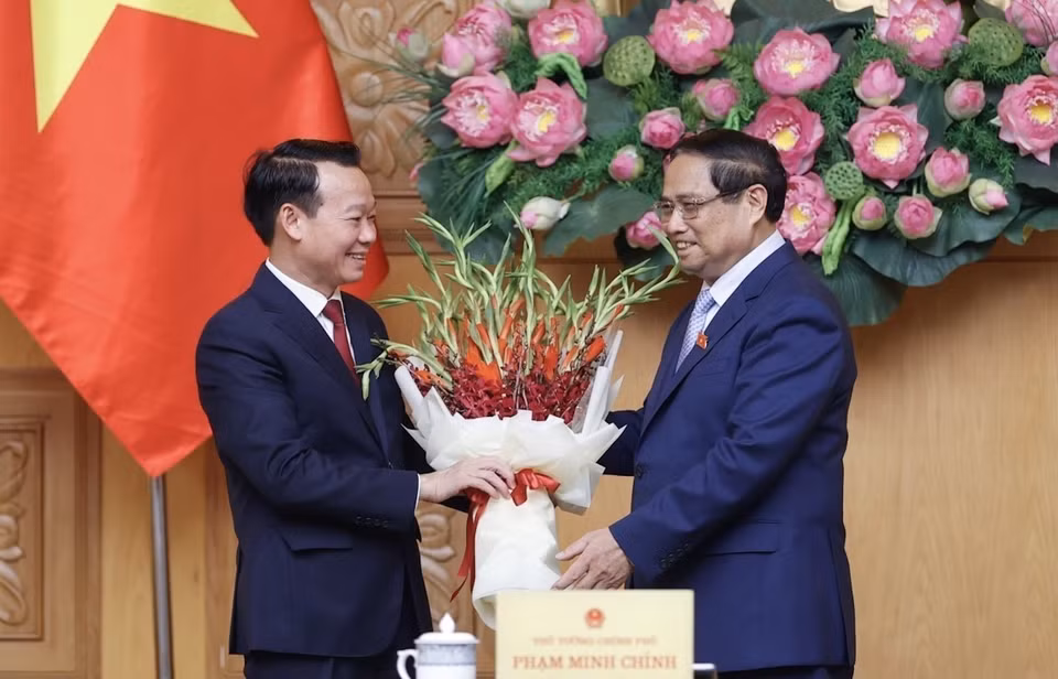 Thủ tướng Phạm Minh Chính tặng hoa chúc mừng tân Bộ trưởng Bộ Tài nguyên và Môi trường Đỗ Đức Duy. (Ảnh: Dương Giang/TTXVN)