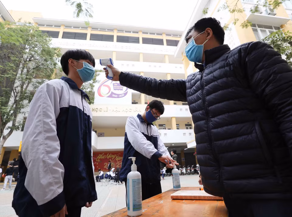 Trường THPT Trần Nhân Tông, quận Hai Bà Trưng (Hà Nội) thực hiện đo thân nhiệt, sát khuẩn tay cho cán bộ, giáo viên và học sinh mỗi khi ra, vào trường (ảnh chụp sáng 29/1). (Ảnh: Thanh Tùng/TTXVN)