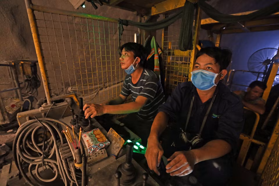 Các công nhân điều khiển máy đào hầm. (Ảnh: Huy Hùng/TTXVN)