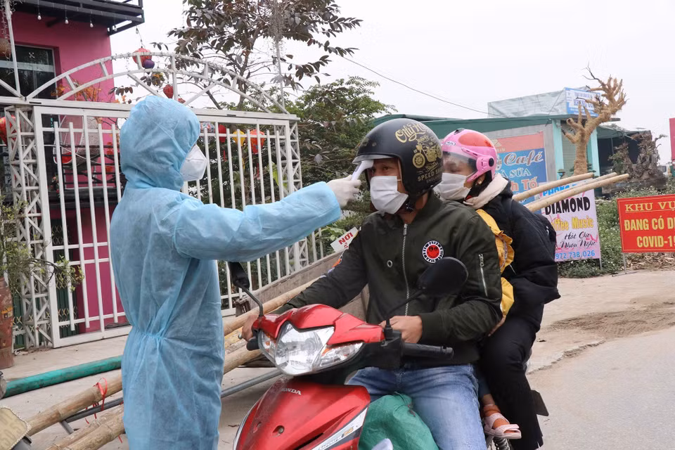 Kiểm tra thân nhiệt cho người vào địa bàn tỉnh Bắc Ninh tại chốt kiểm soát dịch bệnh xã Lâm Thao, huyện Lương Tài. (Ảnh: Thanh Thương/TTXVN)