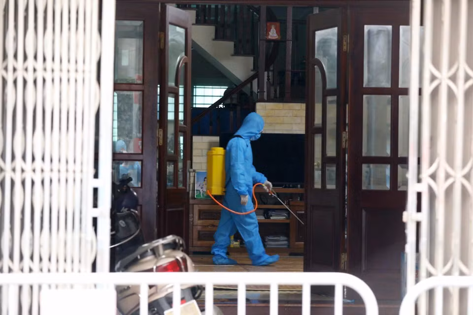 Nhân viên y tế phường Xuân Phương phun khử khuẩn tại hộ gia đình nghi nhiễm dịch. (Ảnh: Minh Quyết/TTXVN)