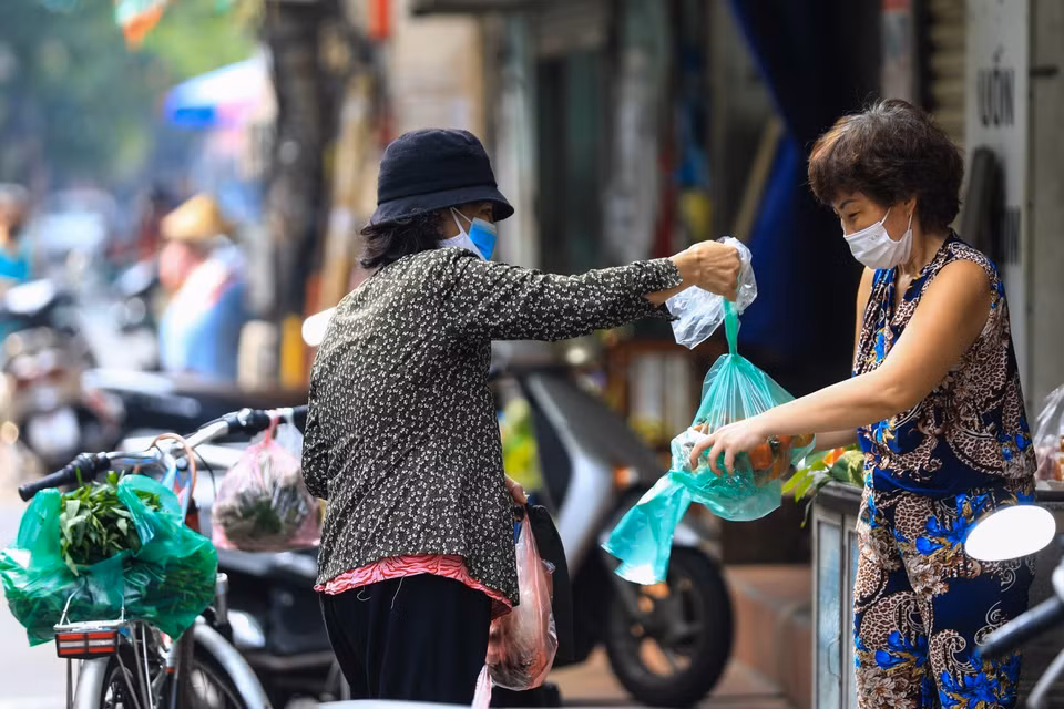 Niềm vui của các bà nội trợ khi có thể ra đường đi chợ sau gần 1 tháng cách ly y tế. (Ảnh: Thành Đạt/TTXVN)