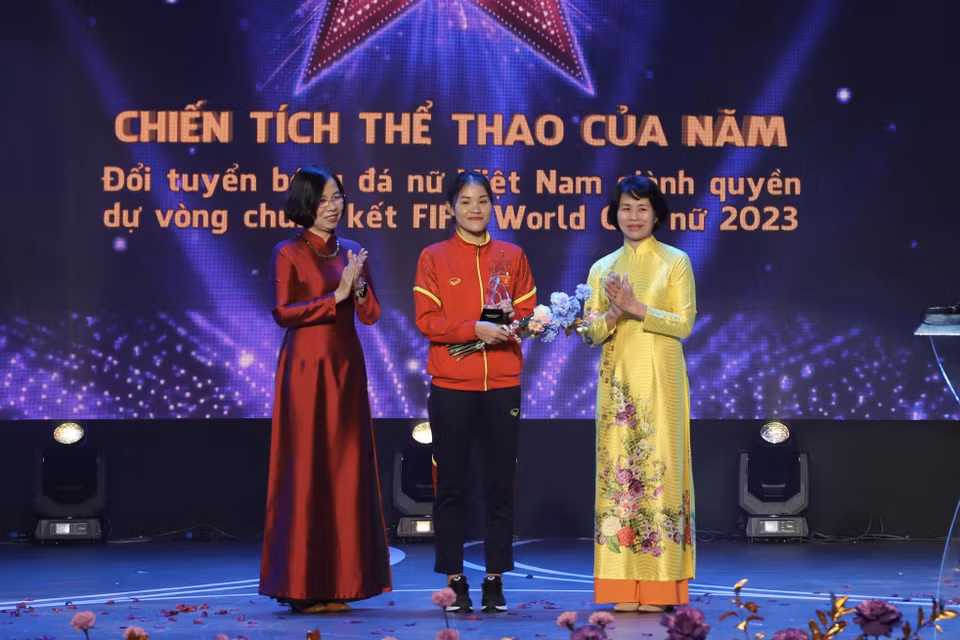 Tổng Giám đốc Thông tấn xã Việt Nam Vũ Việt Trang (áo dài đỏ) trao giải “Chiến tích thể thao của năm”. (Ảnh: Hồng Giang/TTXVN)