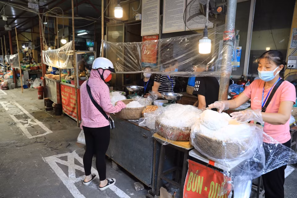 Tại chợ Cống Vị (quận Ba Đình) thực hiện nghiêm quy định 5K, người dân đến mua phải quét mã QR-code và đứng giãn cách. (Ảnh: Thành Đạt/TTXVN)