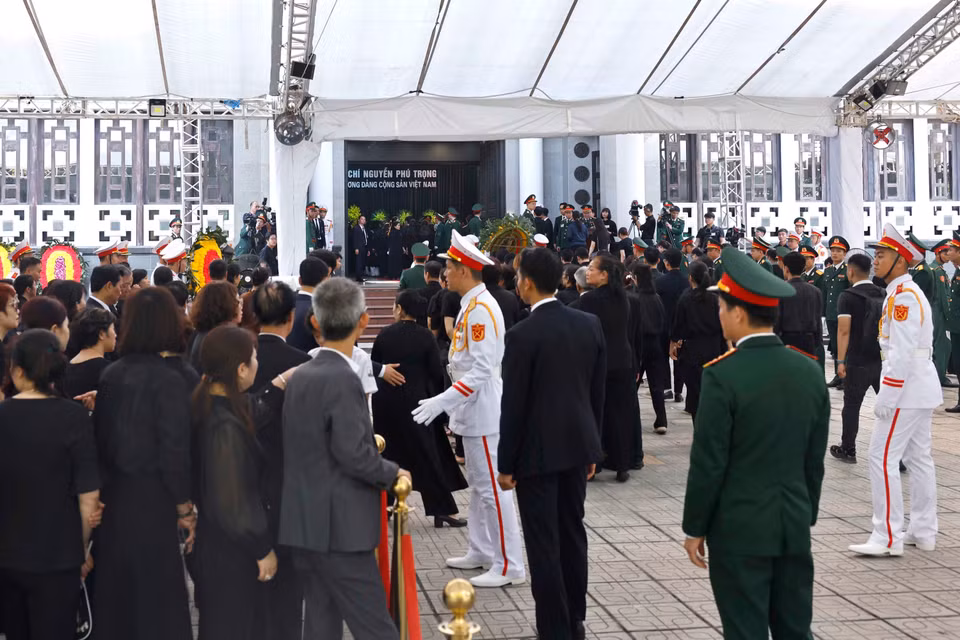 Lực lượng quân đội và công an hỗ trợ người dân đến viếng Tổng Bí thư Nguyễn Phú Trọng tại Nhà tang lễ Quốc gia số 5 Trần Thánh Tông, Hà Nội, sáng 26/7. (Ảnh: TTXVN)