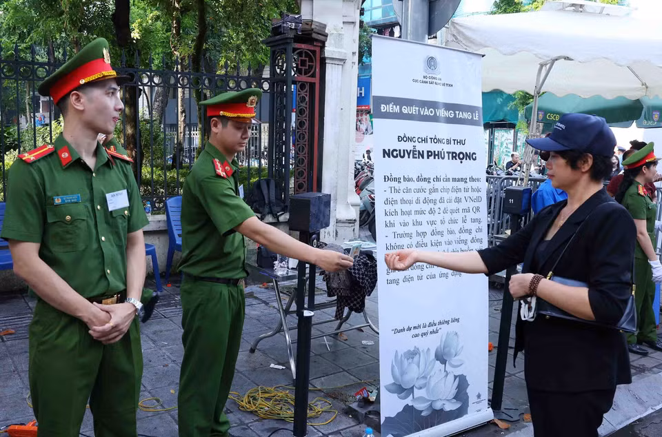Lực lượng công an giúp người dân đến viếng Tổng Bí thư Nguyễn Phú Trọng tại Nhà tang lễ Quốc gia số 5 Trần Thánh Tông, Hà Nội, sáng 26/7. (Ảnh: TTXVN)