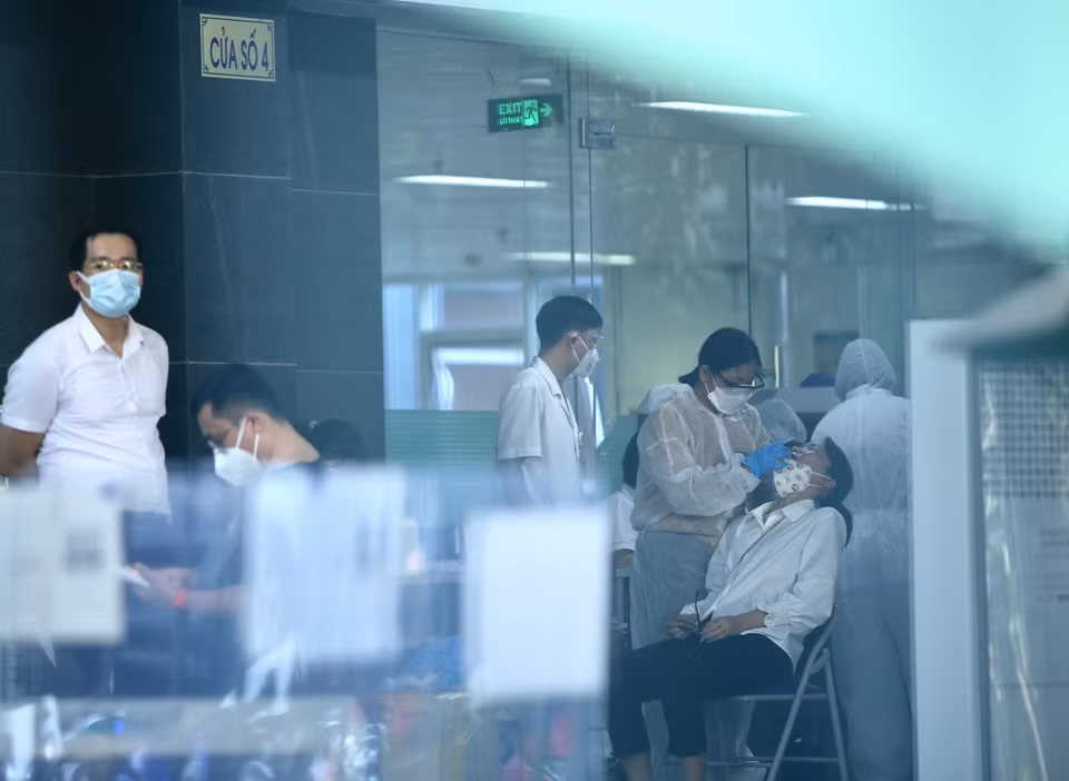 Lực lượng y tế lấy mẫu sàng lọc SARS-CoV-2 cho những người trong tòa D, Bệnh viện Việt Đức chiều 30/9. (Ảnh: Hoàng Hiếu/TTXVN)