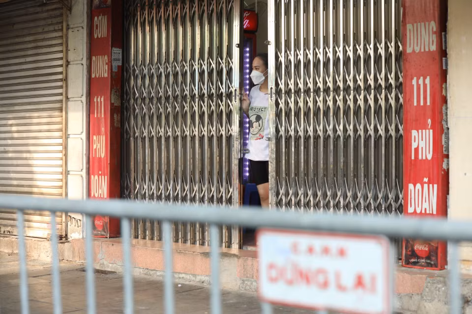 Các hộ dân phía bên ngoài cổng bệnh viện được yêu cầu đóng của và chờ lấy mẫu xét nghiệm. (Ảnh: Minh Quyết/TTXVN)