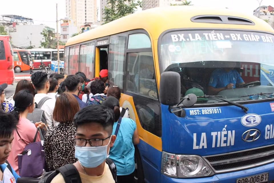 Mỗi khi xe vào khu vực chờ, hành khách ào ào lên xe nhằm kiếm cho mình một chỗ ngồi dễ thở trong dịp nghỉ lễ này. (Ảnh: Việt Hùng/Vietnam+)