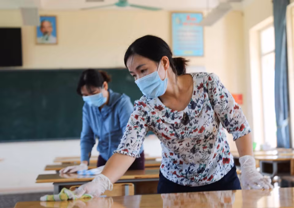 Giáo viên trường THCS Chàng Sơn, huyện Thạch Thất vệ sinh lớp học chuẩn bị đón học sinh trở lại trường. (Ảnh: Thanh Tùng/TTXVN)