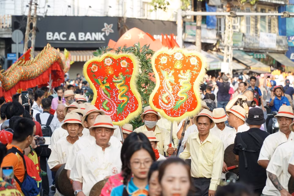 Đoàn diễu hành nghệ thuật đường phố cùng đông đảo người dân đi qua đường Hải Thượng Lãn Ông (Quận 5). (Ảnh: Thu Hương/TTXVN)