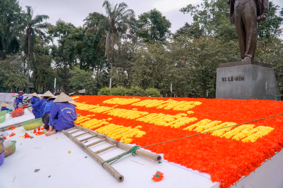 Nhân viên Công ty Cây xanh đang trang trí tường hoa chào mừng tại Vườn hoa Lê-nin. (Ảnh: Minh Hiếu/Vietnam+)