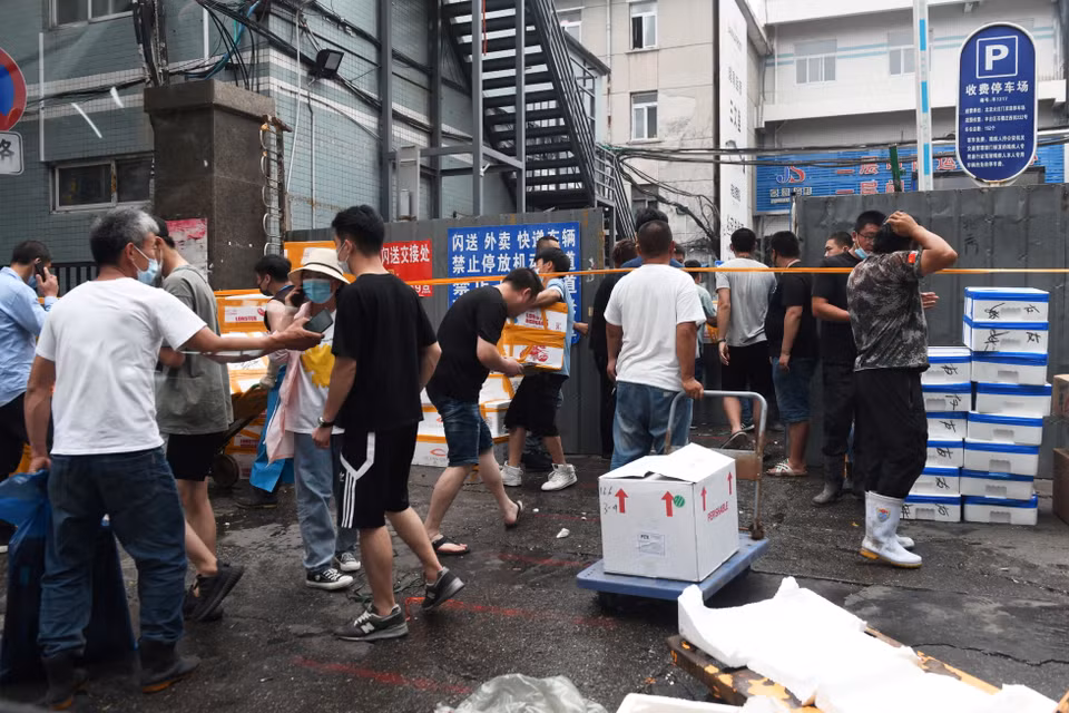 Người dân chuyển hàng hóa khỏi chợ Tân Phát Địa ở Bắc Kinh, Trung Quốc, ngày 13/6, sau khi chợ phải đóng cửa để khử trùng do phát hiện các ca nhiễm COVID-19 mới. (Ảnh: AFP/TTXVN)