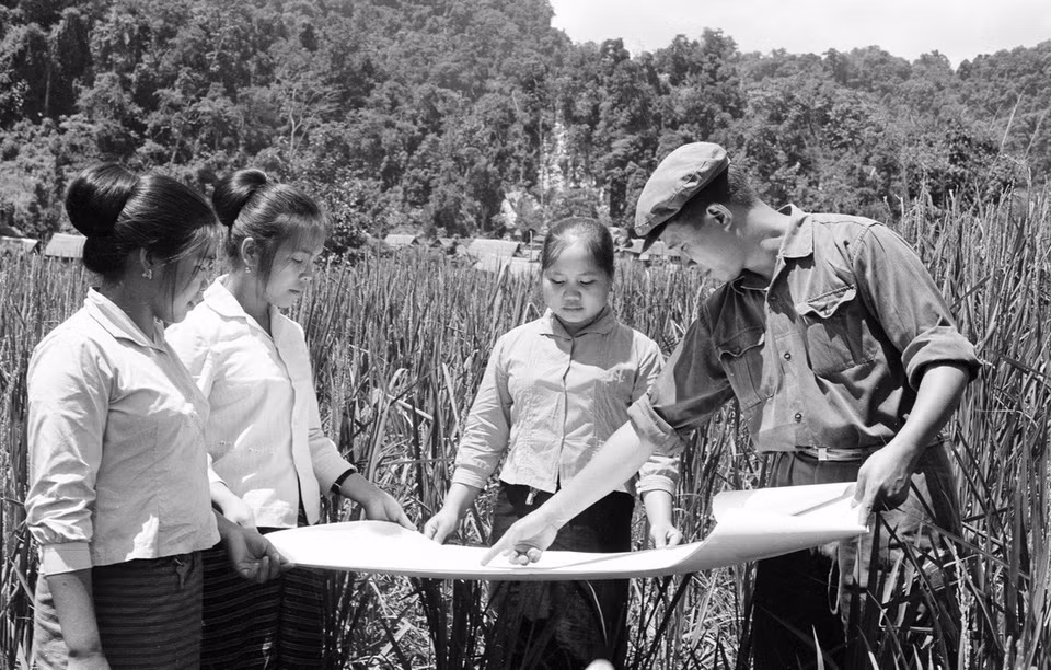 Chuyên gia nông nghiệp Việt Nam hướng dẫn học sinh Lào về quy hoạch ruộng bậc thang và kiểm tra giống lúa trồng thí nghiệm. (Ảnh: TTXVN)