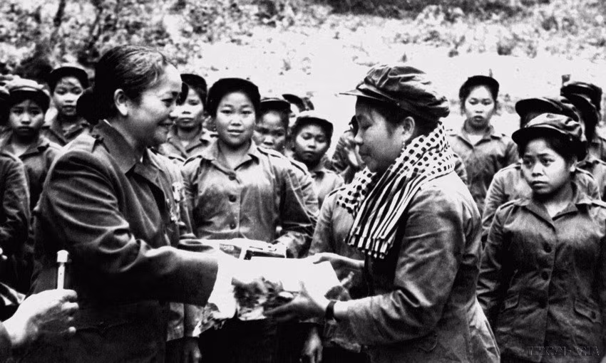 Chủ tịch Hội Liên hiệp Phụ nữ miền Nam Việt Nam Nguyễn Thị Định trao tặng phẩm cho đại đội nữ pháo binh trong chuyến thăm hữu nghị vùng giải phóng Lào (25-29/4/1974). (Ảnh: Tư liệu TTXVN)
