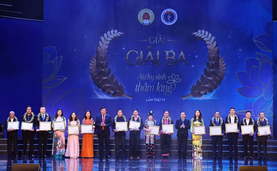 Ông Lại Xuân Môn, Uỷ viên Trung ương Đảng, Phó trưởng Ban Thường trực Ban Tuyên giáo Trung ương và ông Đỗ Xuân Tuyên, Thứ trưởng Bộ trưởng Bộ Y tế trao giải ba cuộc thi viết “Sự hy sinh thầm lặng” lần VI cho các tác giả và chứng nhận nhân vật trong tác phẩm. (Ảnh: Thống Nhất/TTXVN)