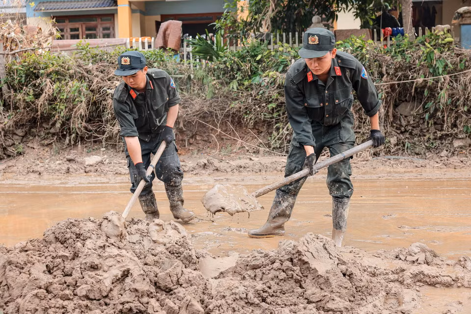 Cảnh sát cơ động hỗ trợ giúp dọn dẹp đường xá, giúp giao thông huyện Bảo Yên, tỉnh Lào Cai nhanh chóng thông suốt, an toàn. (Ảnh: Hoàng Hiếu/TTXVN)