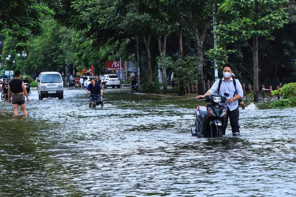 Người dân vẫn phải lội nước qua đoạn đường hồ Văn Quán, quận Hà Đông. (Ảnh: Tuấn Anh/TTXVN)