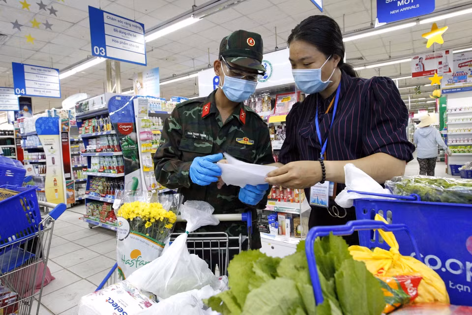 Nhiều chiến sỹ còn lúng túng, nhờ trợ giúp thông tin, hàng hóa từ các nhân viên siêu thị để đi chợ giúp dân đúng và đầy đủ theo nhu cầu. (Ảnh: Thanh Vũ/TTXVN)