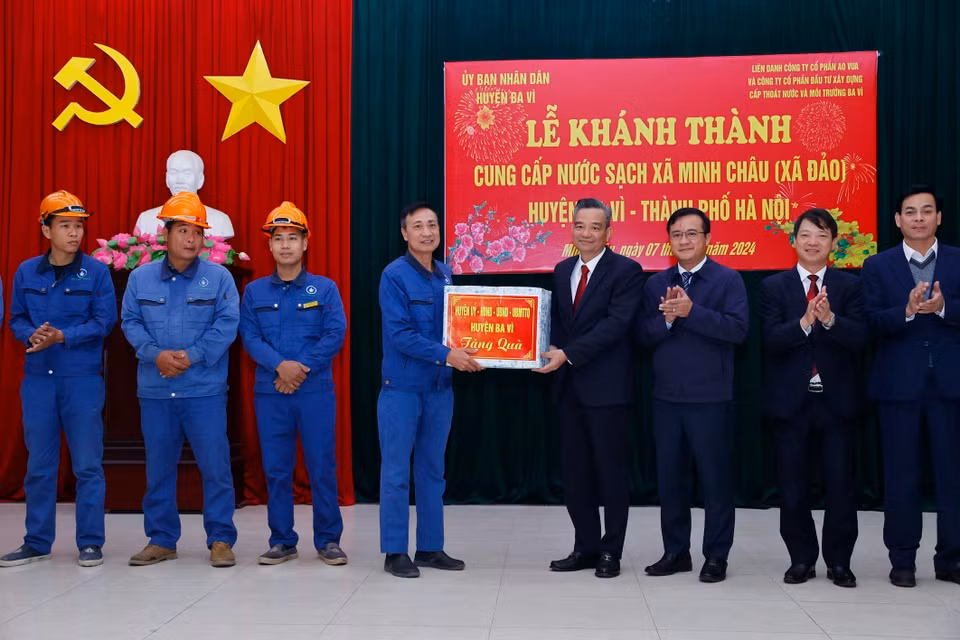 Lãnh đạo huyện Ba Vì tặng quà cho đơn vị thi công đường ống nước sạch tới xã Minh Châu. (Ảnh: Minh Quyết/TTXVN)