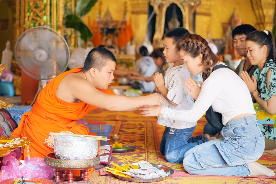 Nhà sư buộc chỉ cổ tay cho người dân. (Ảnh: Đỗ Bá Thành/TTXVN)