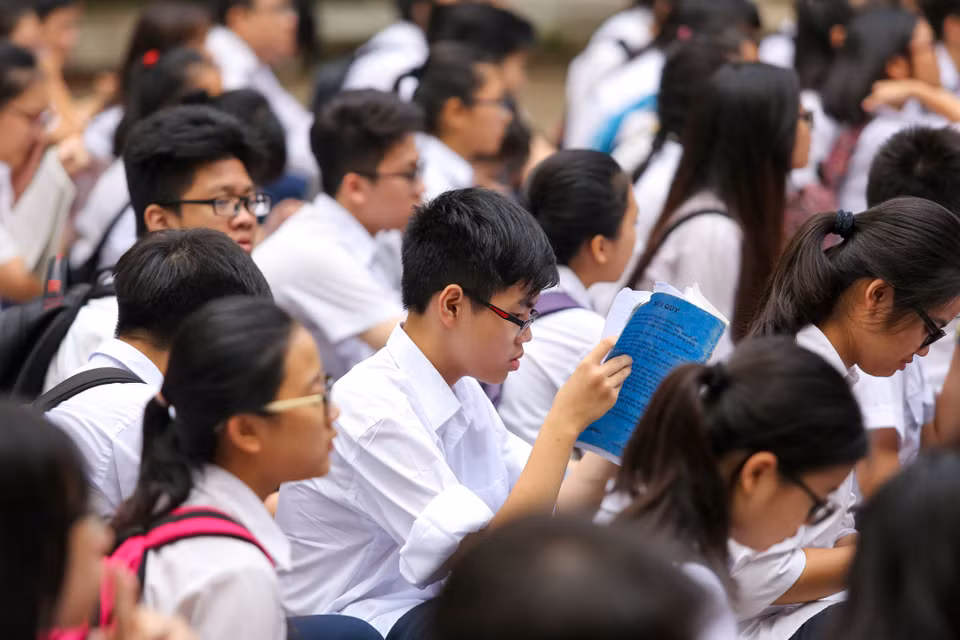 Cho đến giờ tập trung, nhiều thí sinh vẫn còn chăm chú đọc lại bài. (Ảnh: Minh Sơn/Vietnam+)
